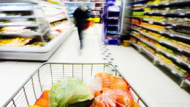 Carrinho de compras com vegetais no supermercado.