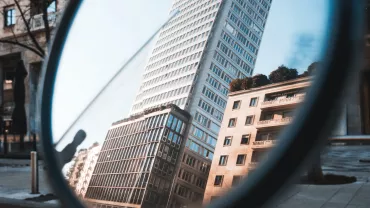 Reflexo de prédio moderno em espelho de bicicleta.