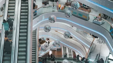 Vista aérea de um shopping com escadas rolantes e decoração moderna em espiral.